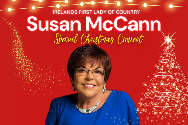 Susan Mc Cann country singer in blue top with a red background and christmas lights